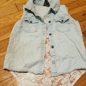 A light wash denim vest with a lace back